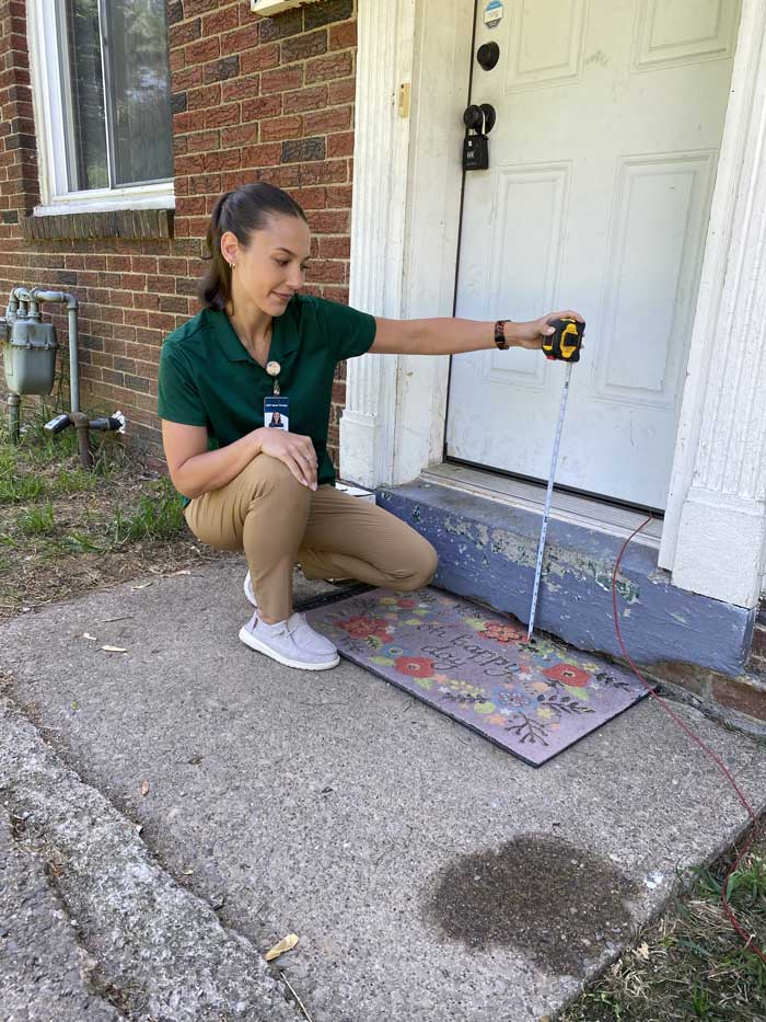 Occupational Therapist measuring entryway threshold of client home.